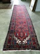 A Caucasian style red ground runner, approx. 330 x 118cm