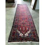 A Caucasian style red ground runner, approx. 330 x 118cm