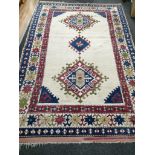 A Turkish ivory ground polychrome wool rug 260cm x 164cm.