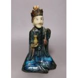 A 19th century Chinese flambé glazed seated figure of an immortal, 25cm