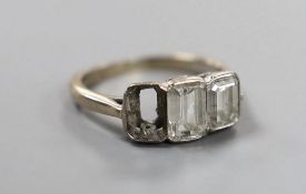 A modern 18ct white gold and two (ex three) stone graduated emerald cut diamond set ring, size G,