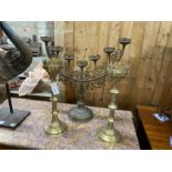 Two brass Gothic style pricket candlesticks, largest height 62cm and a brass Menorah candlestand