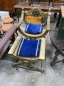 A classical style gilt x-frame elbow chair, width 73cm, depth 52cm, height 96cm and a matching