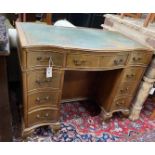 A reproduction George III style mahogany serpentine shaped kneehole desk, length 97cm, width 55cm,