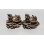 Two Chinese bronze models of dragon turtles on a pile of cash, 10cm