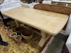 A rectangular bleached oak refectory dining table on four turned pillars with central stretcher,