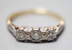 A yellow metal and illusion set three stone diamond ring, size O, gross weight 2.4 grams.