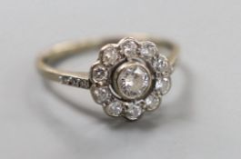 An 18ct white metal and eleven stone diamond set circular cluster ring, size N, gross weight 3.4