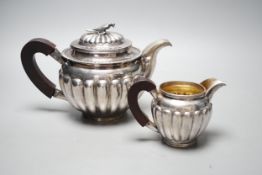 A Chinese Straits? demi fluted white metal teapot and cream jug, with rosewood handles and bird