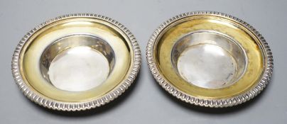 A pair of George III parcel gilt silver circular stands, with gadrooned borders, Emes & Barnard,