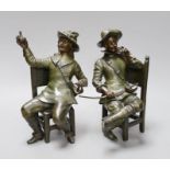 A pair of early 20th century patinated bronzed metal figures of seated cavaliers, 25 cms high,