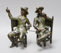 A pair of early 20th century patinated bronzed metal figures of seated cavaliers, 25 cms high,