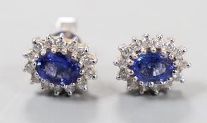 A modern pair of 750 white metal, sapphire and diamond set oval cluster earrings, length 10mm, gross