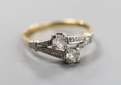 An 18ct, plat and two stone diamond crossover ring, with diamond set shoulders, size N/O, gross
