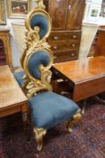 A pair of ornate foliate carved gilt scroll hall chairs with black suede upholstery, height 160cm