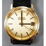 A gentleman's yellow metal Bulova Accutron wrist watch, on a black leather strap, case diameter