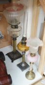 Three assorted glass and metal oil lamps, tallest 59cms excluding funnel