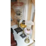 Three assorted glass and metal oil lamps, tallest 59cms excluding funnel