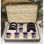 A set of six blue and gilt edged coffee cups and saucers, the cups with pierced silver holders,