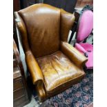 A Victorian style tan leather upholstered wingback armchair, width 78cm, depth 84cm, height 100cm