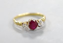 A yellow metal, single stone ruby and two stone diamond set ring, size N, gross weight 2.7 grams.