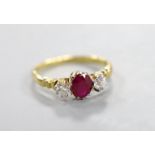 A yellow metal, single stone ruby and two stone diamond set ring, size N, gross weight 2.7 grams.