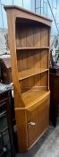 An Ercol elm 'Windsor' standing corner cabinet, width 73cm, depth 41cm, height 179cm
