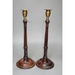 A pair of George III style carved mahogany candlesticks, with brass sconces, 38cms high