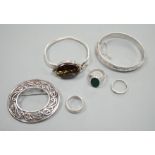 A 1970's silver and oval quartz set bangle, two other white metal bangles and three assorted rings.