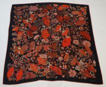 An Hermes wool scarf, with fan and flower motifs on a black ground, in Hermes cloth bag 132 cm.