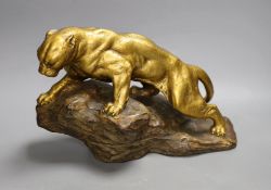 A gilt terracotta model of a panther on a rock, 21cms high