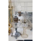 Three oil lamps, two with glass bases, tallest 56cms high,