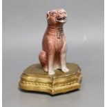 A Chinese porcelain model of a seated dog on gilt wood stand, 19cm tall