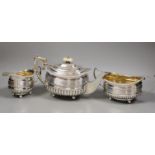A matched George III demi fluted and reeded silver three piece tea set by Alice & George