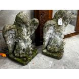 A pair of weathered reconstituted stone eagle and dolphin garden ornaments, height 52cm