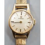 A lady's 9ct Omega manual wind wrist watch, on a 9ct gold bracelet, gross weight 16.3 grams.