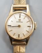 A lady's 9ct Omega manual wind wrist watch, on a 9ct gold bracelet, gross weight 16.3 grams.