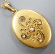 A yellow metal and seed pearl set oval locket stamped 56? (one flower motif with pearl missing),