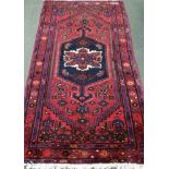 A Caucasian style burgundy ground rug, 200 x 110cm