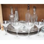 A stylish oval chromed metal two handled tray, with assorted decanters, glassware and cocktail