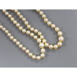 Two single strand graduated cultured pearl necklaces, both with diamond set clasps, one stamped