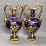 A pair of blue painted two-handled gilt pottery vases with birds amongst ornate gilt decoration.