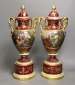 A pair of ornate Vienna style two handled urns bearing covers, with painted love scene and red
