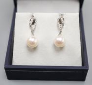 A modern pair of 14k white metal, cultured pearl and diamond set drop earrings, 24mm, gross weight
