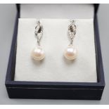 A modern pair of 14k white metal, cultured pearl and diamond set drop earrings, 24mm, gross weight