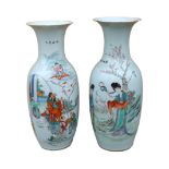 A pair of Japanese polychrome decorated porcelain baluster vases decorated with figures in