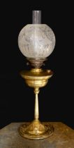 An Edwardian brass oil lamp, with etched glass globe, duplex mechanism and Art Nouveau embossed