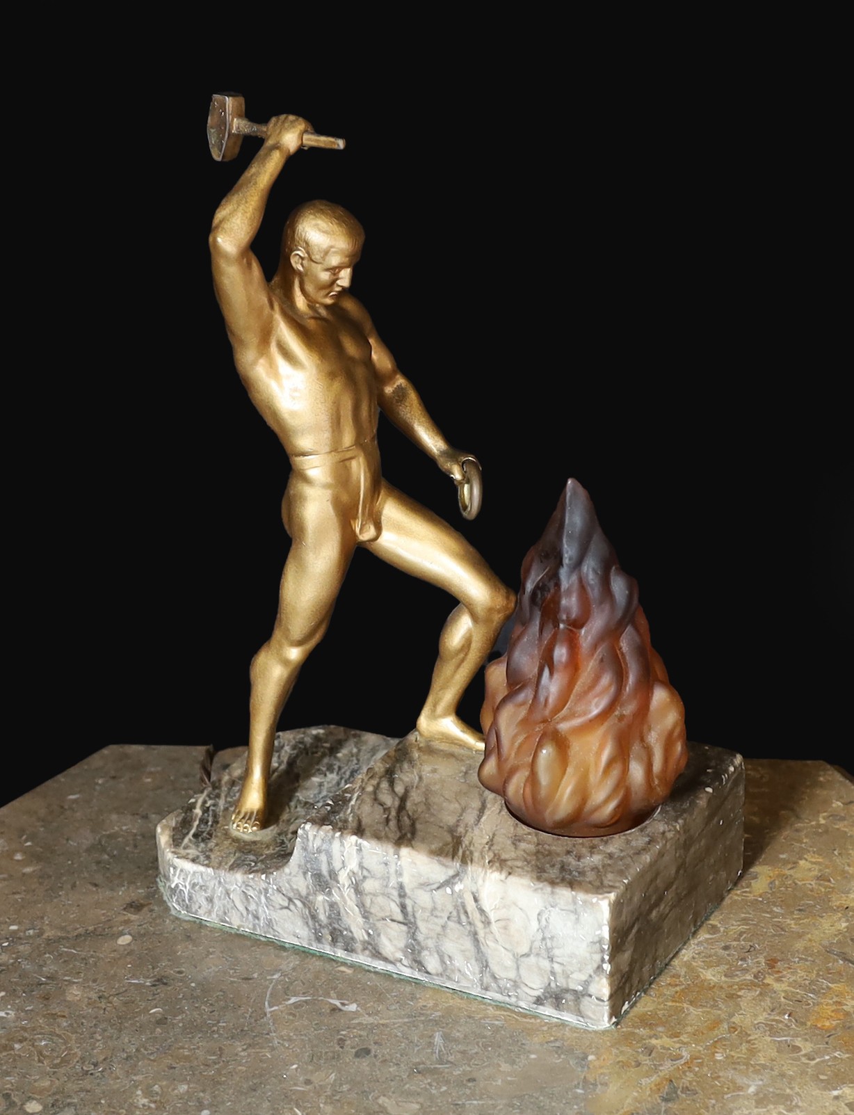 A 1930s Austrian bronzed spelter and marble lamp base modelled as Vulcan, stamped Bergman to the