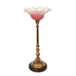 A late 19 century English lacquered bronze and glass table lamp with edged pink glass shade,