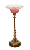 A late 19 century English lacquered bronze and glass table lamp with edged pink glass shade,